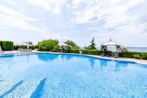 a large swimming pool with a blue sky at Royal Bay - Beachfront Apartments with Self Check-In in Sveti Vlas