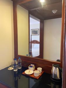 La salle de bains est pourvue d'une coiffeuse avec un miroir et d'une table. dans l'établissement The Gateway Hotel Pasumalai Madurai, à Madurai