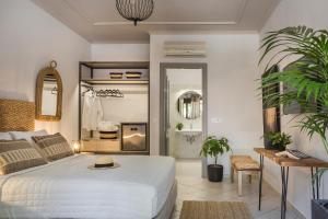 a bedroom with a white bed and a living room at Makis Hotel in Skala