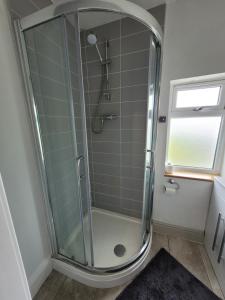 a shower in a bathroom with a glass shower stall at Room@87 in Ellesmere Port