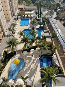 - une vue sur la piscine du complexe bordée de palmiers dans l'établissement Flat Prive das Thermas II - R3 Caldas, à Caldas Novas