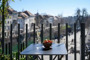 a table with a bowl of fruit and a glass of wine at Zlata Ladjica Boutique Hotel in Ljubljana