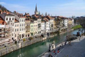 a group of buildings next to a river with buildings at Zlata Ladjica Boutique Hotel in Ljubljana