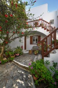 a house with a staircase and a tree with flowers at Casa Cozy in Mýkonos City