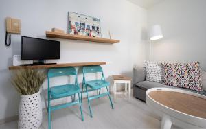 a living room with two blue chairs and a couch at Casa Cozy in M&yacute;konos City