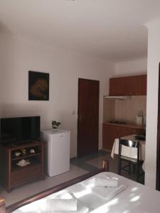 a living room with a television and a kitchen at Apartments Muhar in Sveti Stefan