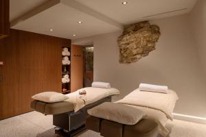 a therapy room with two beds and a rock on the wall at Zlata Ladjica Boutique Hotel in Ljubljana