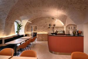 un ristorante con un muro di mattoni, tavoli e sedie di Zlata Ladjica Boutique Hotel a Lubiana