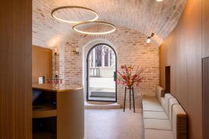 a room with a brick wall and a ceiling with two lights at Zlata Ladjica Boutique Hotel in Ljubljana