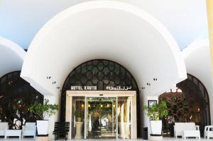Kanta Resort and Spa في سوسة: مدخل لمحل به طاولات وكراسي بيضاء