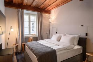 a bedroom with a large bed and a window at Zlata Ladjica Boutique Hotel in Ljubljana