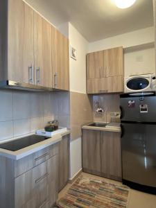 a kitchen with wooden cabinets and a black refrigerator at Sunset Apartment in Struga +8 photos
