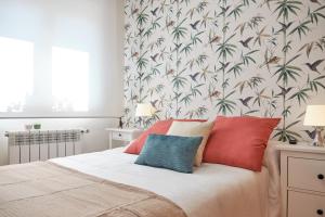 um quarto com uma cama com almofadas vermelhas e azuis em Peregrina Pension 3 em O Pedrouzo