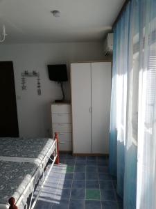 een slaapkamer met een bed, een dressoir en een televisie bij Ferienhaus Bozena Appartment 1 in Vrsar
