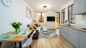 kuchnia i salon z drewnianym stołem i jadalnią w obiekcie Apartament nad Łomnicą w mieście Karpacz