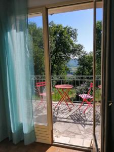 a sliding glass door with a table and chairs on a patio at ALABRENA in Féneyrols