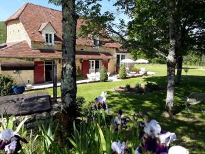 a house with trees and flowers in the yard at La bergerie de Laura in Vaillac