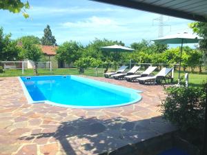 a swimming pool with chairs and an umbrella at Tenuta Santa Lucia in Silea