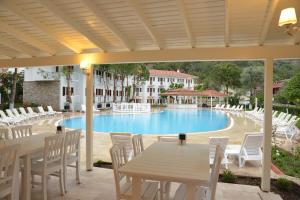 un patio con mesa, sillas y piscina en White Hotel, en Ölüdeniz