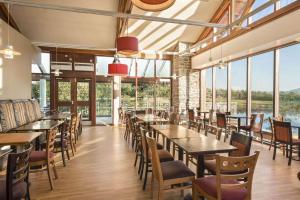 uma sala de jantar com mesas, cadeiras e janelas em Days Inn Lockerbie - Annandale Water em Johnstonebridge