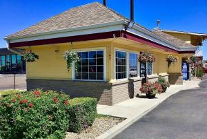 a yellow house with flowers in front of it at Super 8 by Wyndham Ontario in Ontario