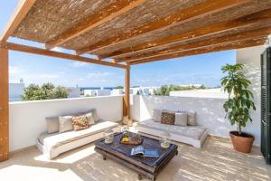 a patio with a couch and a table at Villa Conguitos in Sant Lluis