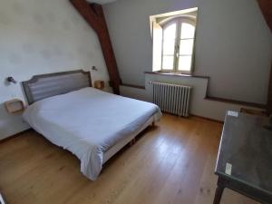 ein Schlafzimmer mit einem weißen Bett und einem Fenster in der Unterkunft Hôtel Restaurant du Cheval Blanc in Saint-Boil