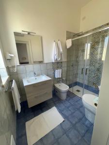 La salle de bains est pourvue d'un lavabo, de toilettes et d'une douche. dans l'établissement Albergo Moschella, à Lampedusa