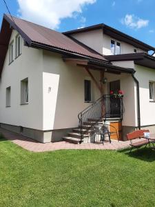 a white house with a balcony and a patio at Apartament Orlik in Tylicz