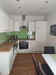 a kitchen with white cabinets and a table with chairs at Appartementhaus Lisa in Afritz