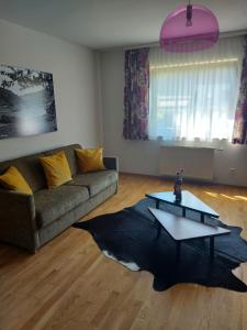 ein Wohnzimmer mit einem Sofa und einem Tisch in der Unterkunft Appartementhaus Lisa in Afritz
