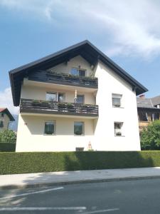 um edifício branco com um telhado preto em Apartment April em Bled