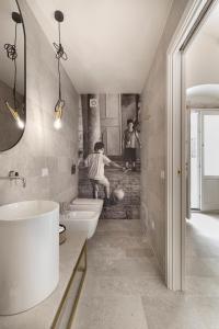 two people in a bathroom with two sinks and a tub at Cantunéra Rooms Dependance in Noto