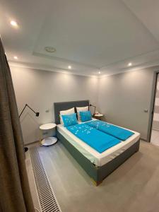 バラトンフェニヴェシュにあるHajnal Nyaralóházのベッドルーム(青い枕の大型ベッド1台付)