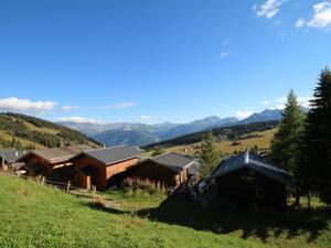 a group of buildings on a hill with mountains in the background at Studio Les Saisies, 1 pièce, 3 personnes - FR-1-293-3 in Les Saisies