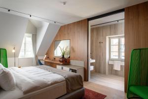 a bedroom with a large bed and a bathroom at Zlata Ladjica Boutique Hotel in Ljubljana