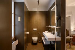a bathroom with a white toilet and a sink at Zlata Ladjica Boutique Hotel in Ljubljana