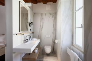 a white bathroom with a sink and a toilet at Zlata Ladjica Boutique Hotel in Ljubljana