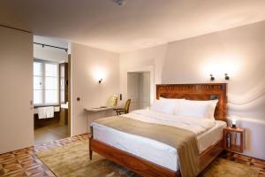 a bedroom with a large bed and a bathroom at Zlata Ladjica Boutique Hotel in Ljubljana