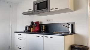 a kitchen with a sink and a microwave at Studio@Domburg in Domburg