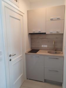 a small kitchen with white cabinets and a sink at Apartments Boreta in Budva