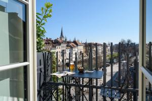 a balcony with a table and a view of a city at Zlata Ladjica Boutique Hotel in Ljubljana
