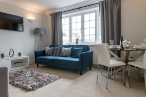 a living room with a blue couch and a table at Park Cottage Willows Riverside Park in Windsor