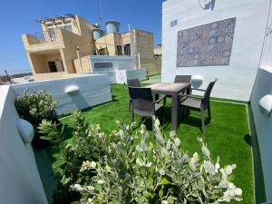 a patio with a table and chairs on a roof at St.Joseph Apartment in Marsaskala