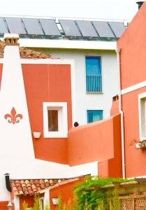 un edificio rojo y blanco con ventanas y techo en Fleur de Lis, en Belas