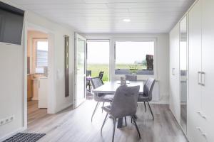 a dining room with a table and chairs at Bungalow Neuwarft, Wohnung 2 in Dagebüll