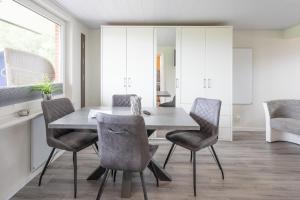 a dining room with a table and chairs at Bungalow Neuwarft, Wohnung 2 in Dagebüll