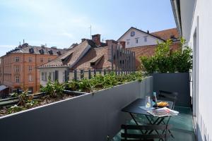 a balcony with a table and a view of buildings at Zlata Ladjica Boutique Hotel in Ljubljana