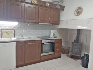 a kitchen with wooden cabinets and a stove top oven at Casa da Venda do Ferrador in Estremoz