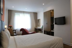 a hotel room with a white bed and a television at Vy House in Hanoi